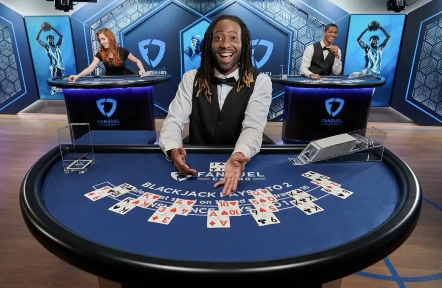 Smiling live dealer presenting cards at a blackjack table