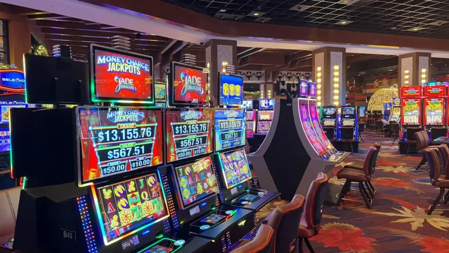 Row of slot machines displaying live progressive jackpot totals on a casino floor