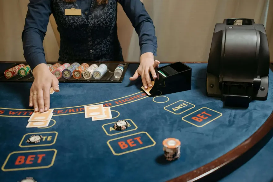 Casino dealer hands dealing cards and chips at a poker table