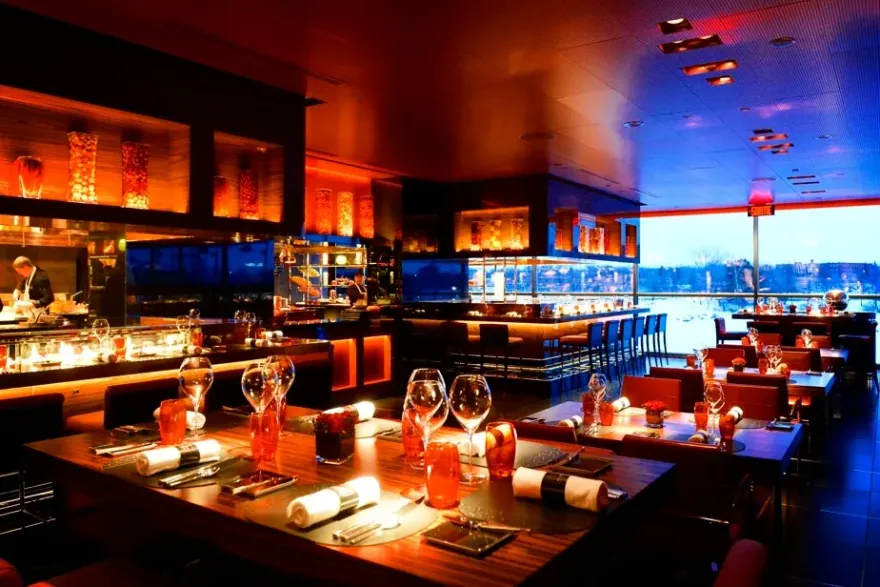 Elegant dining room interior at Casino de Montréal overlooking the river at dusk
