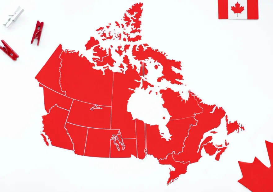 Red paper map of Canada with provincial borders beside a Canadian flag